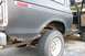 1979 Ford Bronco - The rear quarter panel of a dark gray 1978 Ford Bronco shows significant rust damage around the wheel well.