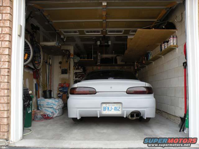 White 1994 Mazda MX-6 parked in a garage, rear view. License plate BFKJ-462