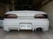 1994 Mazda MX-6 - The rear of a white car is shown, a custom body kit, dual exhaust pipes, and an Ontario license plate.