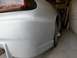 1994 Mazda MX-6 - The rear of a car, prepped for paint, sits in a cluttered garage space.