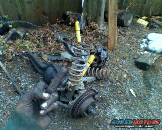 Suspension parts including springs and brake components scattered on the ground