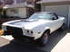1973 Ford Ranchero - This white coupe utility is parked in a driveway in front of a garage and house.
