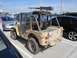 1990 Ford Bronco - This modified jeep, equipped with a heavy machine gun and an American flag decal, is parked in a lot.