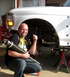 1996 Ford Bronco - A man holds a new shock absorber next to the front suspension of a white 1992 Ford F-150.