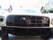 1973 Ford Ranchero - Front view of a white car's grille, a red emblem and horizontal bars, with the hood open.