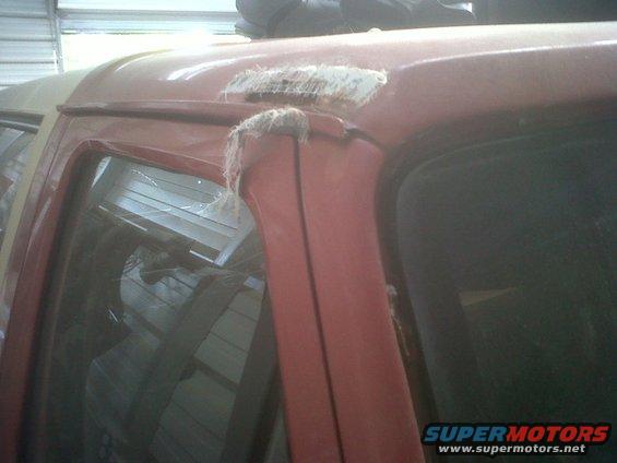 Red SUV door frame with fiberglass repair patch and exposed fibers