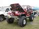 1994 Ford Bronco - Modified Jeep Wrangler on display with its hood raised, next to another vehicle.