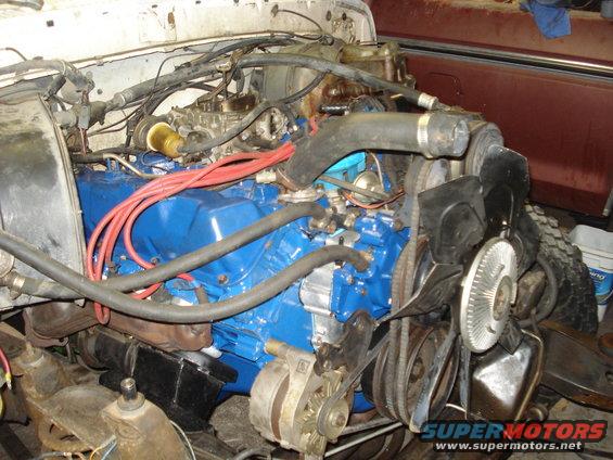 1979 Ford Bronco engine bay with blue engine and red spark plug wires