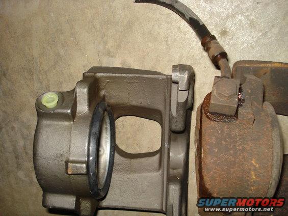 Two brake calipers and a rotor are shown, one caliper is new and the other is rusted
