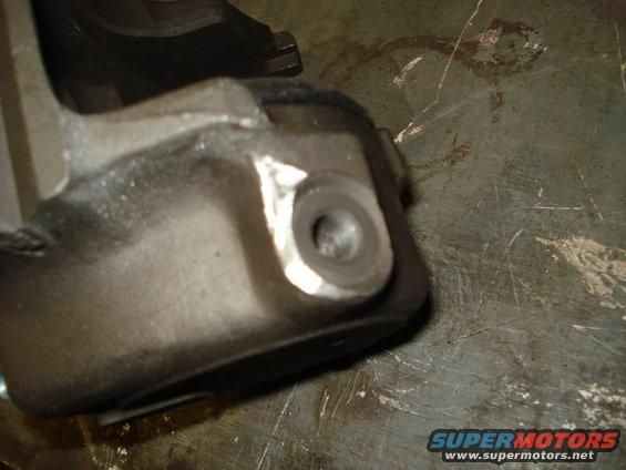 Close-up of a metal brake caliper bracket with a threaded hole