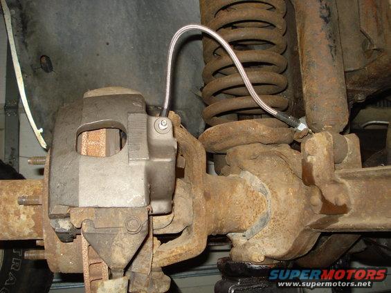 Rusty brake caliper and coil spring assembly on a vehicle part