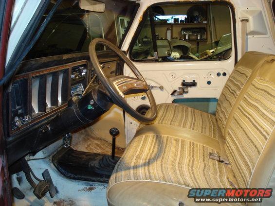 1979 Ford Bronco interior with striped seats, wood-grain dashboard, and floor shifter