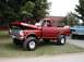 1994 Ford Bronco - Red 1967 Ford F-series pickup truck with hood open, parked on grass next to a blue truck.