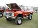 1994 Ford Bronco - This lifted SUV, likely from the 1980s, is displayed with its hood open, revealing the engine bay.