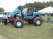 1994 Ford Bronco - Modified Jeep CJ on display with hood open, other vehicles and tents visible in the background.