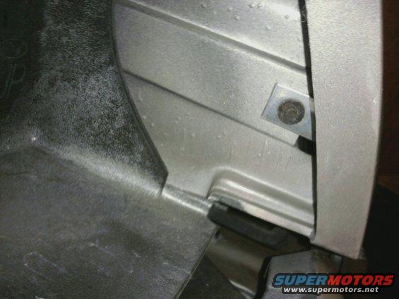 Close-up of a silver-colored vehicle part with a bolt and bracket