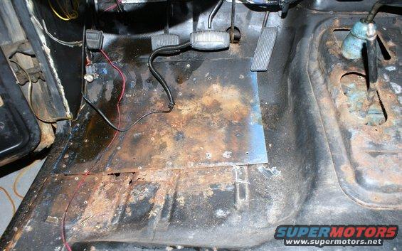 rusted floor pan and pedals inside a vehicle