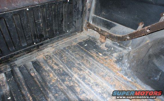 Interior cargo area with ribbed floor and rust spots