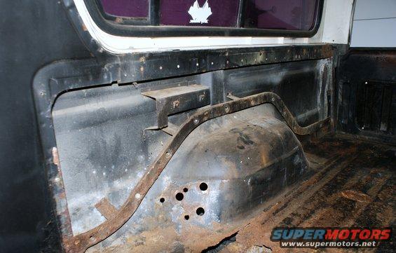 Interior view of a vehicle's cargo area showing rust and exposed metal