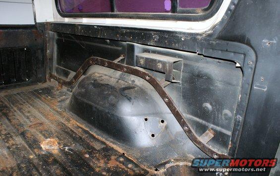 Interior of a vehicle's cargo area, showing the wheel well and floor