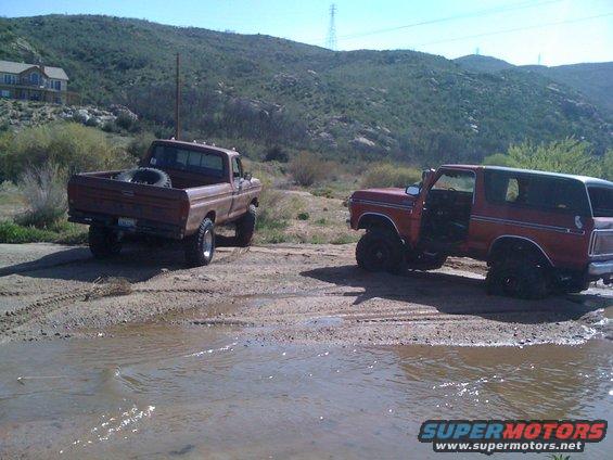 1978 Ford Bronco and a pickup truck parked off-road