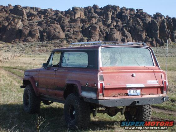 Red SUV with roof rack, rear view. License plate AL 834