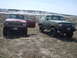 1989 Ford Bronco - A green 1989 Ford Bronco is parked next to a red Jeep Wagoneer in a dry, grassy field.
