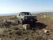 1989 Ford Bronco - A modified Ford Bronco navigates a rocky, off-road trail under a clear sky.