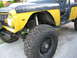 1973 Ford Bronco - This modified 1973 Ford Bronco features a yellow body with a black hood and roll cage, equipped for off-road use.