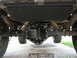 1973 Ford Bronco - Underside view shows the rear differential, leaf springs, and skid plate of a vehicle.