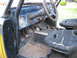 1973 Ford Bronco - The interior of a 1973 Ford Bronco features worn seats, a roll cage, and a basic dashboard with a central gauge.