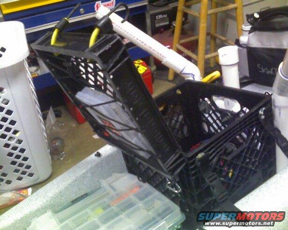 Kayak with two black milk crates and fishing tackle boxes inside