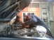 1985 Toyota Pickup/SR5 - Mechanics work on the engine of a truck with its hood open in a garage setting.