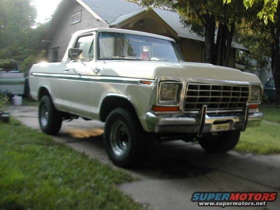 White 1978 Ford Bronco parked on a driveway, front grille and headlights visible