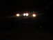 1984 Ford Bronco II - The front of a 1984 Ford Bronco II is visible with its headlights illuminated in the dark.