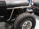 1979 Jeep CJ7 - Close-up of a 1979 Jeep CJ7's front fender and tire, with another vehicle visible behind it.