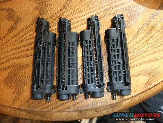 Four black gun magazines on a wooden table