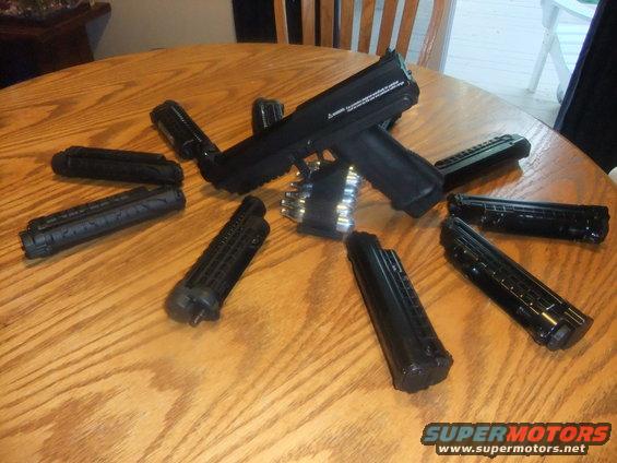 Airsoft gun with several magazines laid out on a wooden table