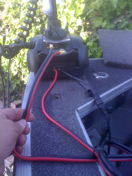 hand connecting red and black wires to trolling motor