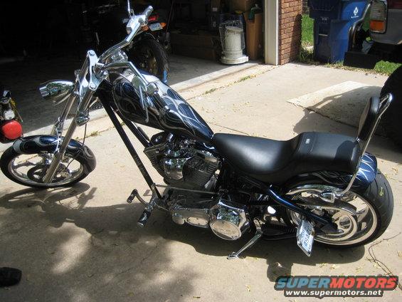 Chopper motorcycle with flame graphics on the tank, parked in a driveway