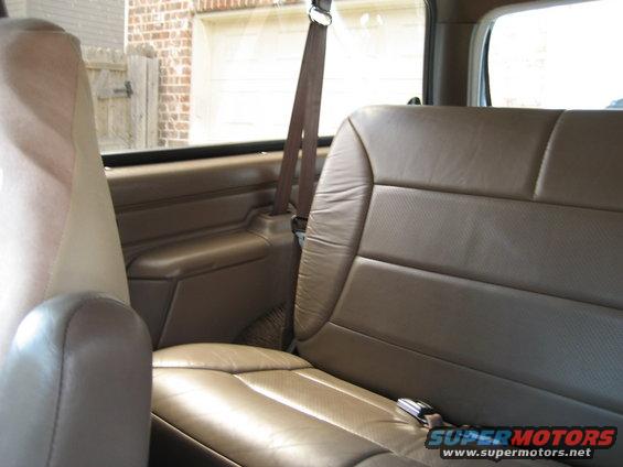 Back seat and interior door panel of a vehicle. A watermark says "SUPERMOTORS www.supermotors.net"