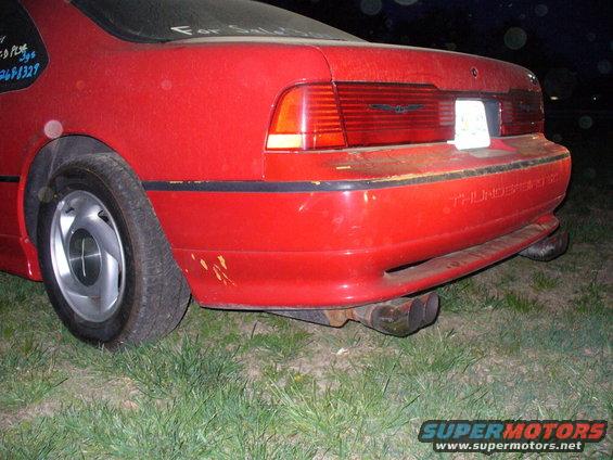 Rear of red 1995 Ford Thunderbird with dual exhaust pipes