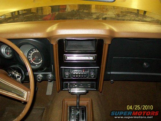 Car dashboard with steering wheel, radio, and shifter. Date stamp shows 04/25/2010