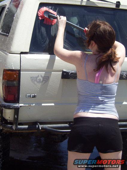 Rear view of white SUV being washed, with 'EFI' badge visible