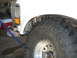 1996 Ford Bronco - Close-up of a white truck's fender and a large off-road tire with a chrome rim.