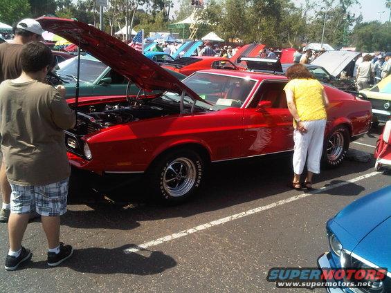 Red 1971 Ford Mustang Mach 1 with hood open at a car show