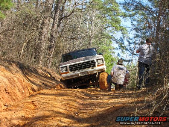 1978 Ford Bronco climbing a steep dirt hill with two people watching