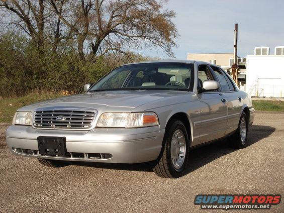 Silver 2000 Ford Crown Victoria sedan parked on gravel, front 3/4 view