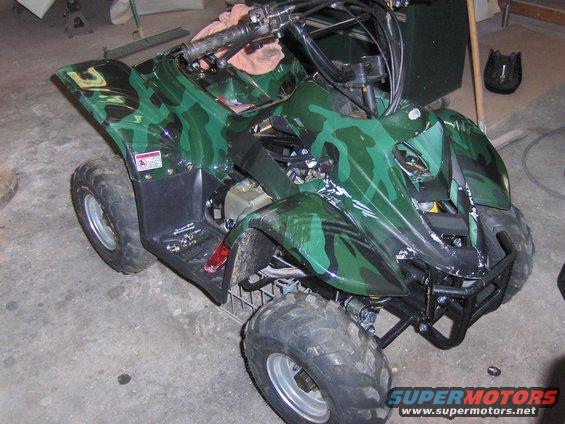Camouflage ATV with number 3 on the fender, parked indoors
