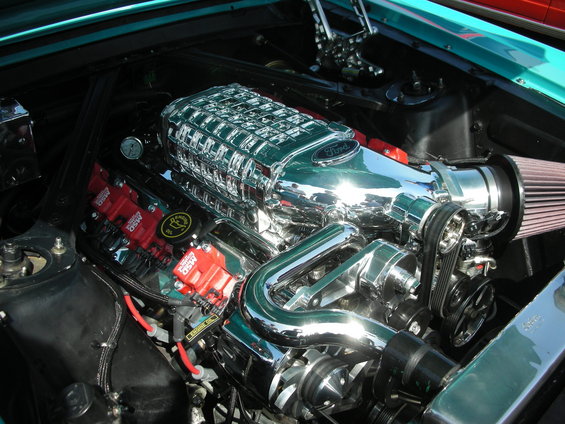 Close-up of a Ford V8 engine with a chrome supercharger and red MSD ignition coils